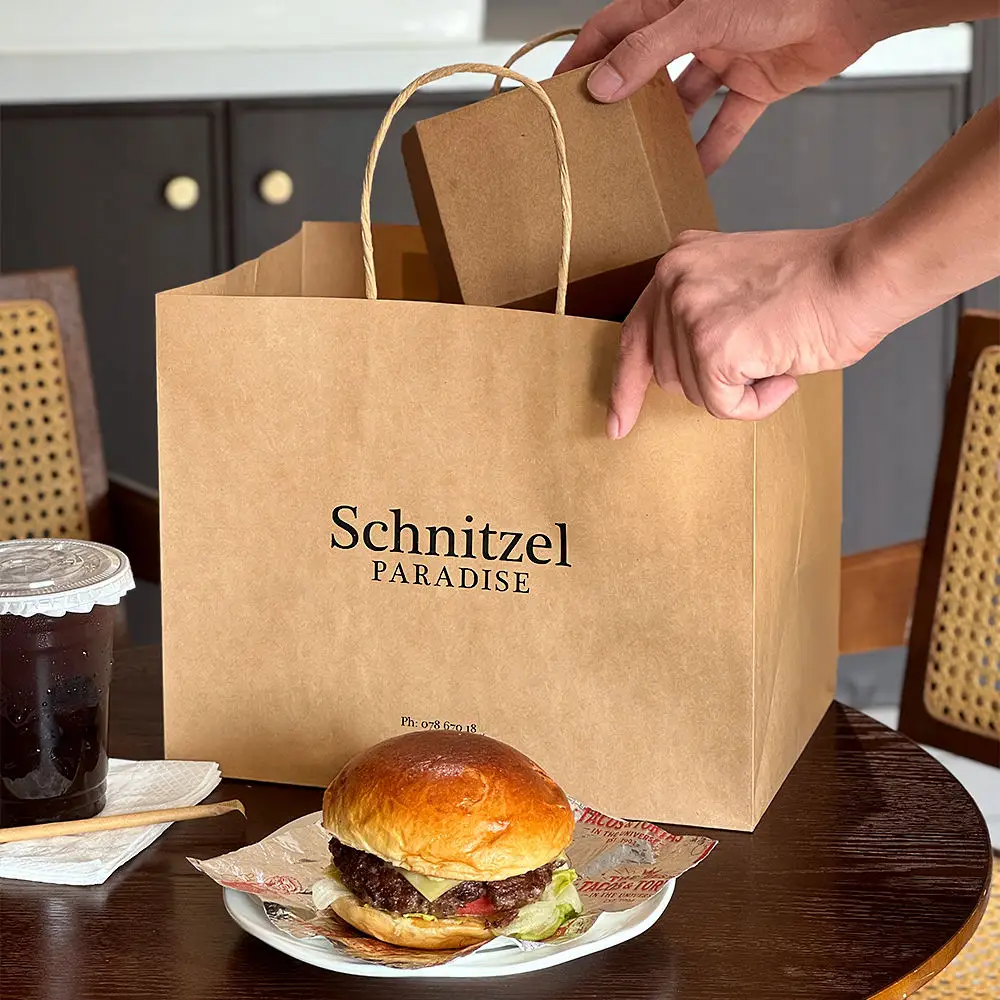 Greaseproof Fried Food Bags - Putting food box into brown kraft takeaway bag with twisted handle